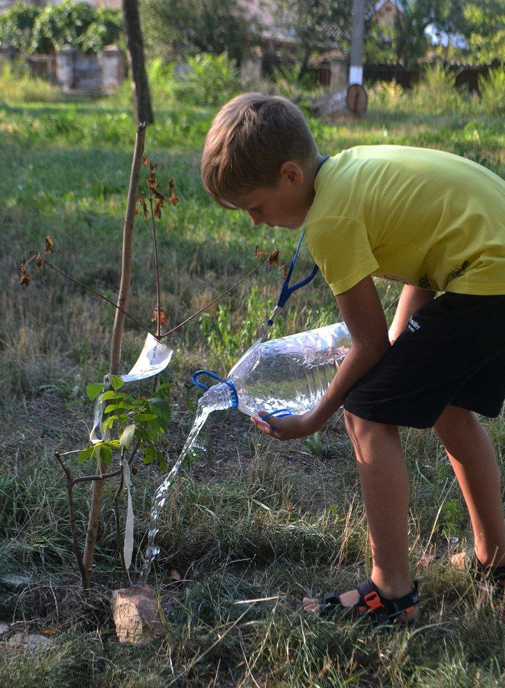 Мальчик поливает деревья в парке Покровском. Лето 2023.
