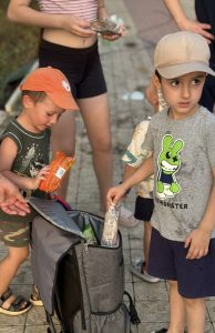 Дети получают мороженное за полив саженцев деревьев.