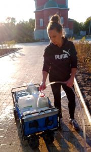 Волонтер Катерина набирает воду в парке Кирова
